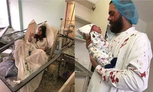 ചില്ലുകൾ തറച്ചുകയറിയ ബെഡിൽ ഒരമ്മ; ചോരപുരണ്ട വസ്​ത്രങ്ങളണിഞ്ഞ്​ കുഞ്ഞിനെ മാറോടണച്ച് പിതാവും