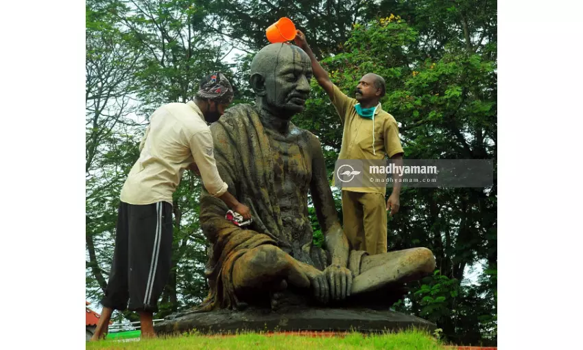 ഗാന്ധി പ്രതിമ ശുചീകരിക്കുന്ന കോർപറേഷൻ ജീവനക്കാർ