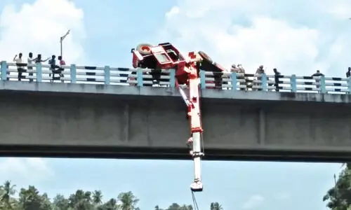 പാ​ല​ത്തി​ന​ടി​യി​ൽ കു​ടു​ങ്ങി​യ വ​ൻ​മ​രം ക​യ​റ്റു​ന്ന​തി​നി​ടെ ക്രെ​യി​ൻ മ​റി​ഞ്ഞു