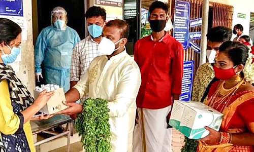 വി​വാ​ഹ ദി​വ​സം കോ​വി​ഡ്​ പ്ര​തിരോ​ധ കി​റ്റു​മാ​യി വ​ധൂ​വ​ര​ന്മാ​ർ