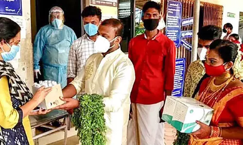 വി​വാ​ഹ ദി​വ​സം കോ​വി​ഡ്​ പ്ര​തിരോ​ധ കി​റ്റു​മാ​യി വ​ധൂ​വ​ര​ന്മാ​ർ