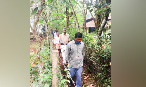 ക​മ്പി​വേ​ലി​ക​ൾ​ക്കി​ട​യി​ലൂ​ടെ രോ​ഗി​യു​മാ​യി ആ​ശു​പ​ത്രി​ യാ​ത്ര