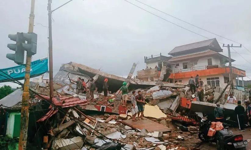 Rescuers looking for survivors trapped in a collapsed building in Mamuju