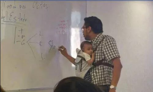 കുഞ്ഞിനെയും നെഞ്ചിലേറ്റി ക്ലാ​െസടുക്കുന്ന വിഭാര്യനായ പ്രഫസറല്ല ഇദ്ദേഹം; വൈറൽ ചിത്രത്തിന്​ പിന്നിലെ വാസ്​തവം ഇതാണ്​