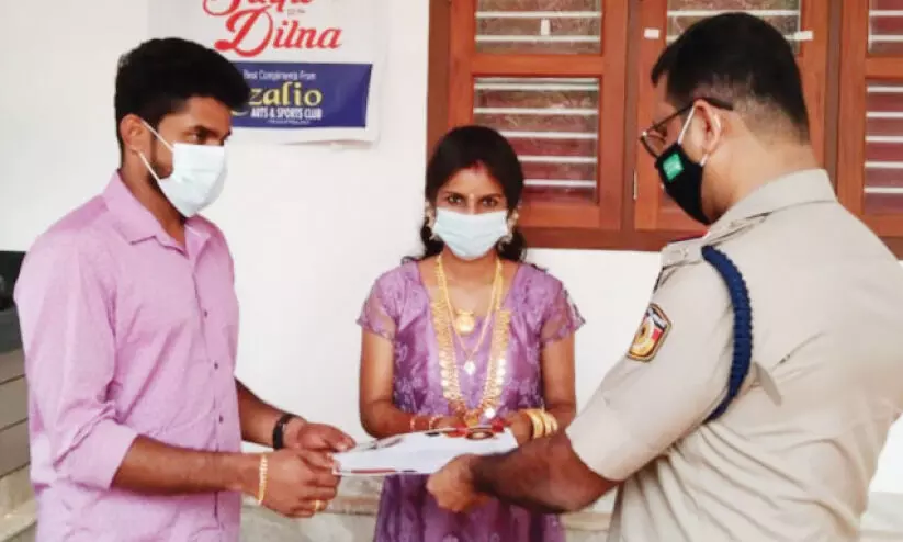 സിഞ്ചു- ദിൽന ദമ്പതികൾക്ക് എടച്ചേരി എസ്.ഐ അരുൺകുമാർ അനുമോദന പത്രം കൈമാറുന്നു