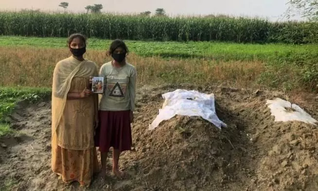 Soni Kumari, and her sister, at the the graves of their parents who succumbed to Covid