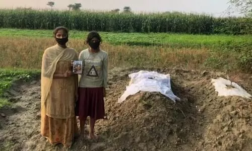 Soni Kumari, and her sister, at the the graves of their parents who succumbed to Covid