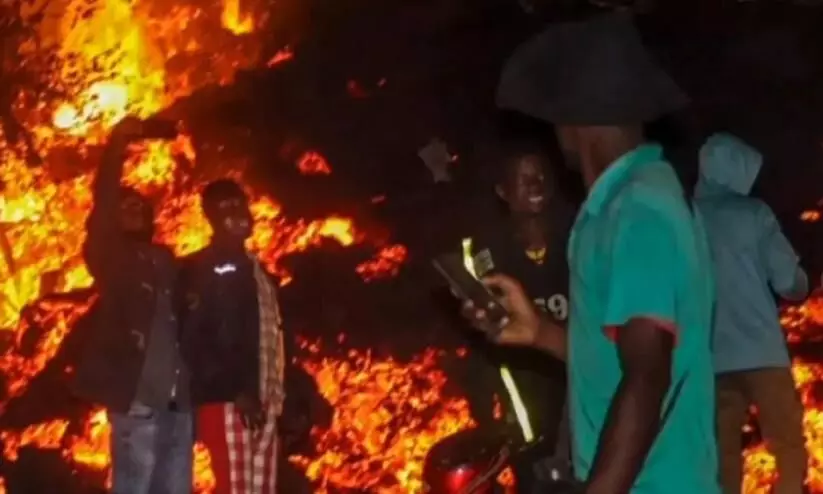 People take selfies in front of volcanic lava that killed 32 people in Congo