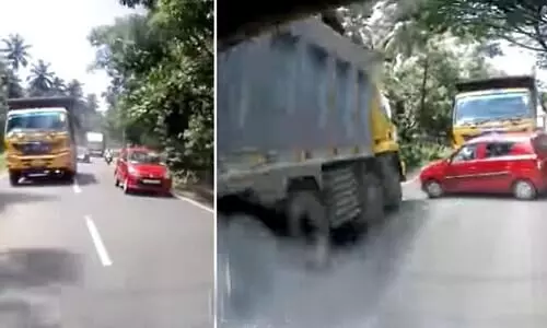 Car nearly gets sandwiched between two huge trucks after