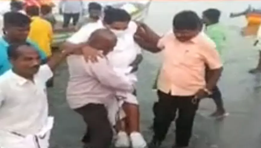 ചെരിപ്പ് നനയാതിരിക്കാൻ മന്ത്രിയെ മത്സ്യത്തൊഴിലാളി പൊക്കിയെടുത്ത് കരയിലെത്തിച്ചു; വിവാദം VIDEO ചെരിപ്പ് നനയാതിരിക്കാൻ മന്ത്രിയെ മത്സ്യത്തൊഴിലാളി പൊക്കിയെടുത്ത് കരയിലെത്തിച്ചു; വിവാദം VIDEO