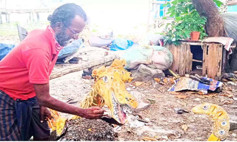 Nasser paints colors on wood