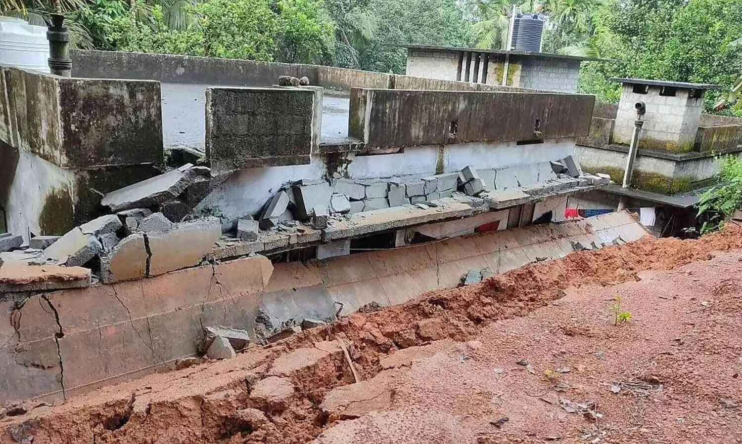 മതില്‍ ഇടിഞ്ഞ് വീടിന് മുകളിലേക്ക് വീണു