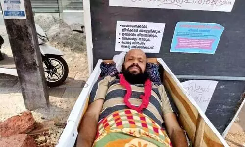 പണിമുടക്കിന് പിന്തുണയുമായി ശവപ്പെട്ടിയിൽ കിടന്ന് പ്രതിഷേധം