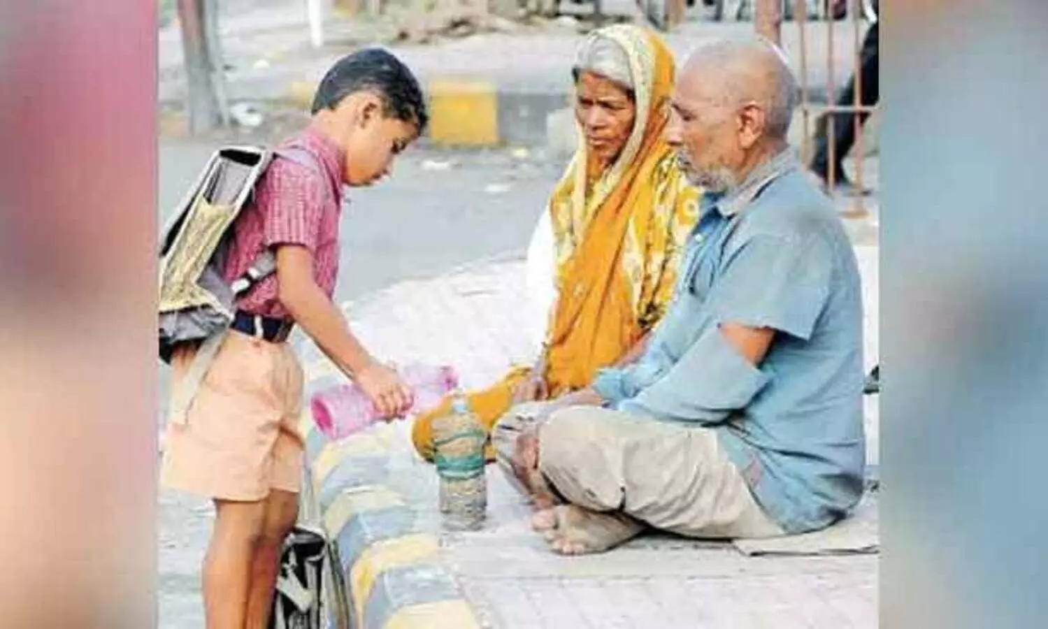 തെരുവിൽ വൃദ്ധ ദമ്പതികൾക്ക് വെള്ളം നൽകുന്ന വിദ്യാർഥിയുടെ ചിത്രം തരംഗമായി