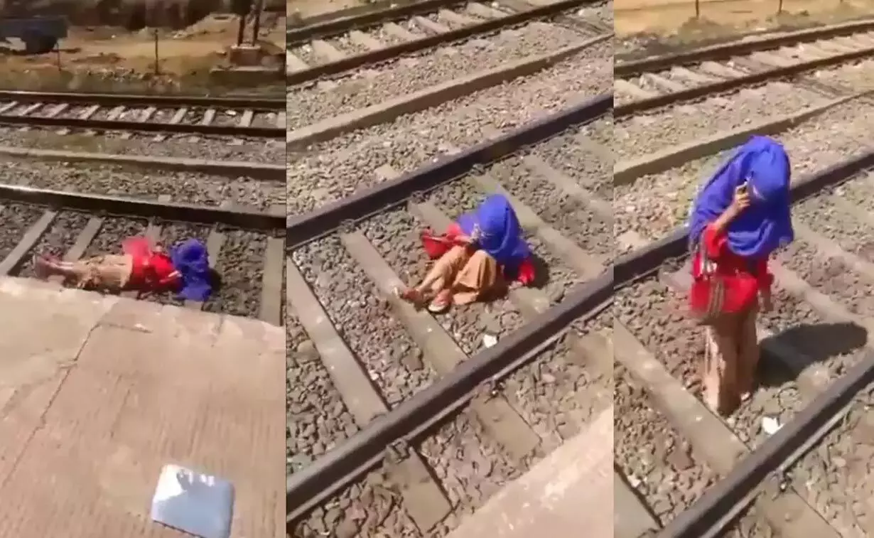 video of woman gossiping over phone while lying on railway track