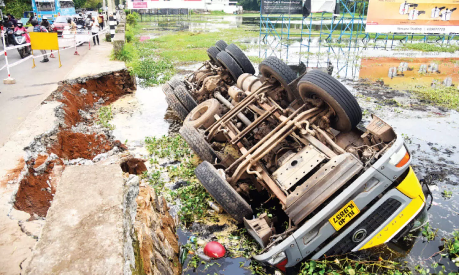 റോഡ് ഇടിഞ്ഞ് കണിമംഗലം പാടത്തേക്ക് ലോറി മറിഞ്ഞു