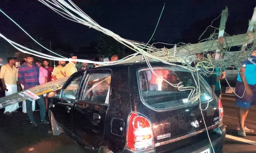 നി​ർ​ത്തി​യി​ട്ട കാ​റി​ൽ വൈ​ദ്യു​ത തൂ​ൺ വീ​ണു