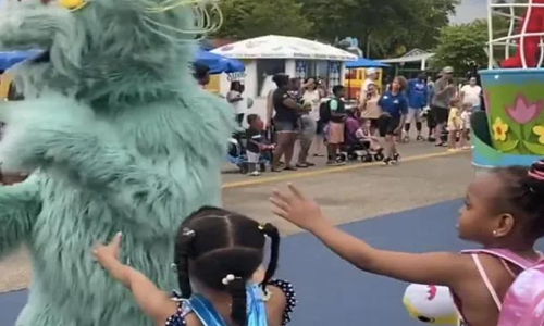 two girls being ignored by one of the characters at Sesame park