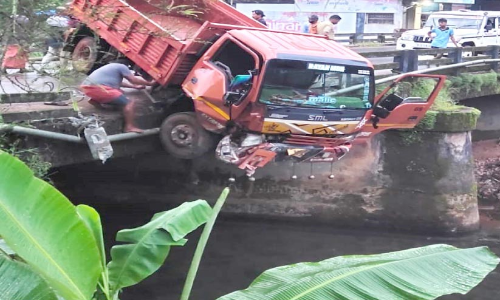 പാലത്തിന്റെ കൈവരി തകർത്ത ടിപ്പർ പുഴയുടെ മുകളിൽ തൂങ്ങി