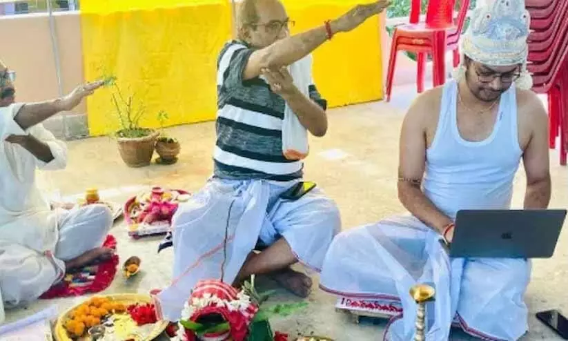 Bengali groom works on laptop during wedding