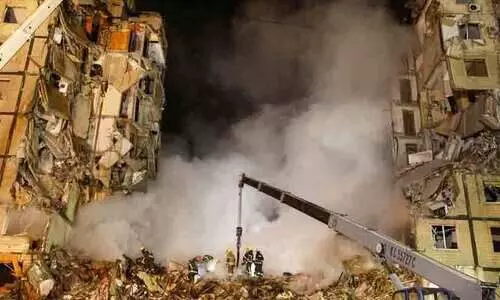 Emergency personnel work at the site where an apartment block was heavily damaged by a Russian missile strike