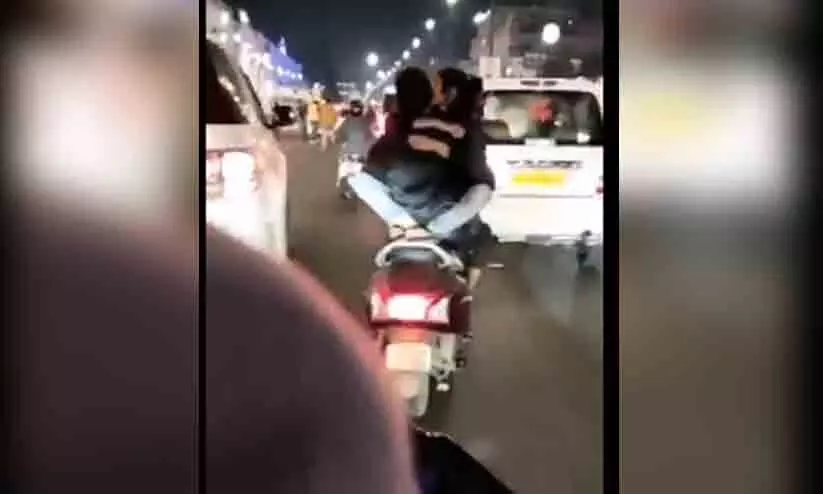 സ്കൂട്ടറിൽ മുഖാമുഖമിരുന്ന് പെൺകുട്ടിയെ കെട്ടിപ്പിടിച്ചും ഉമ്മവെച്ചും യാത്ര; യുവാവ് അറസ്റ്റിൽ-വിഡിയോ സ്കൂട്ടറിൽ മുഖാമുഖമിരുന്ന് പെൺകുട്ടിയെ കെട്ടിപ്പിടിച്ചും ഉമ്മവെച്ചും യാത്ര; യുവാവ് അറസ്റ്റിൽ-വിഡിയോ