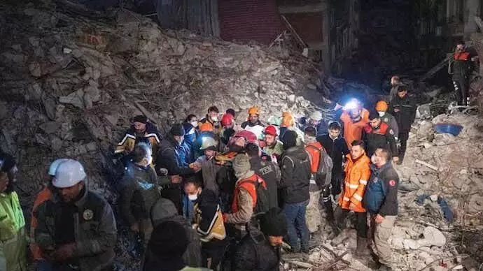 Rescuers evacuate a woman saved from rubbles in Hatay