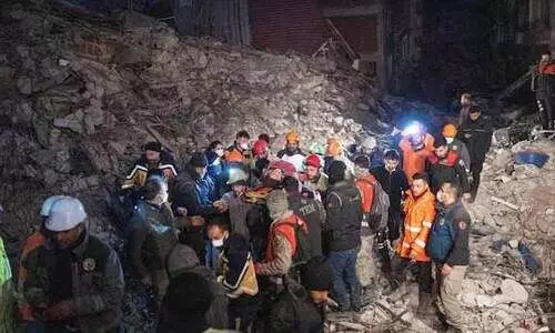 Rescuers evacuate a woman saved from rubbles in Hatay