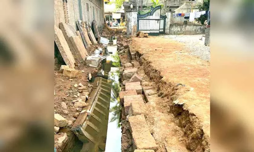 വെള്ളക്കെട്ട് ഒഴിവാക്കാൻ നടപ്പാതയിലെ സ്ലാബുകൾ പൊളിച്ചു വെള്ളക്കെട്ട് ഒഴിവാക്കാൻ നടപ്പാതയിലെ സ്ലാബുകൾ പൊളിച്ചു