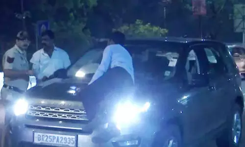 Man Holds On To Bonnet