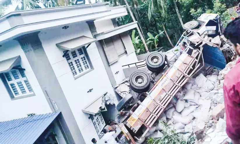 ചരക്കുലോറി വീടിന് മുകളിലേക്ക് മറിഞ്ഞു ചരക്കുലോറി വീടിന് മുകളിലേക്ക് മറിഞ്ഞു