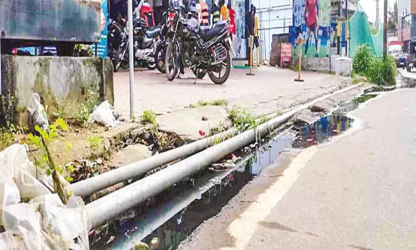 കൊ​ടു​വാ​യൂ​ർ ടൗ​ണി​ൽ ഓ​ട​ക​ൾ​ക്ക് സ്ലാ​ബി​ല്ല; മാ​ലി​ന്യം റോ​ഡി​ൽ, വാ​ഹ​നാ​പ​ക​ടം കൂ​ടു​ന്നു