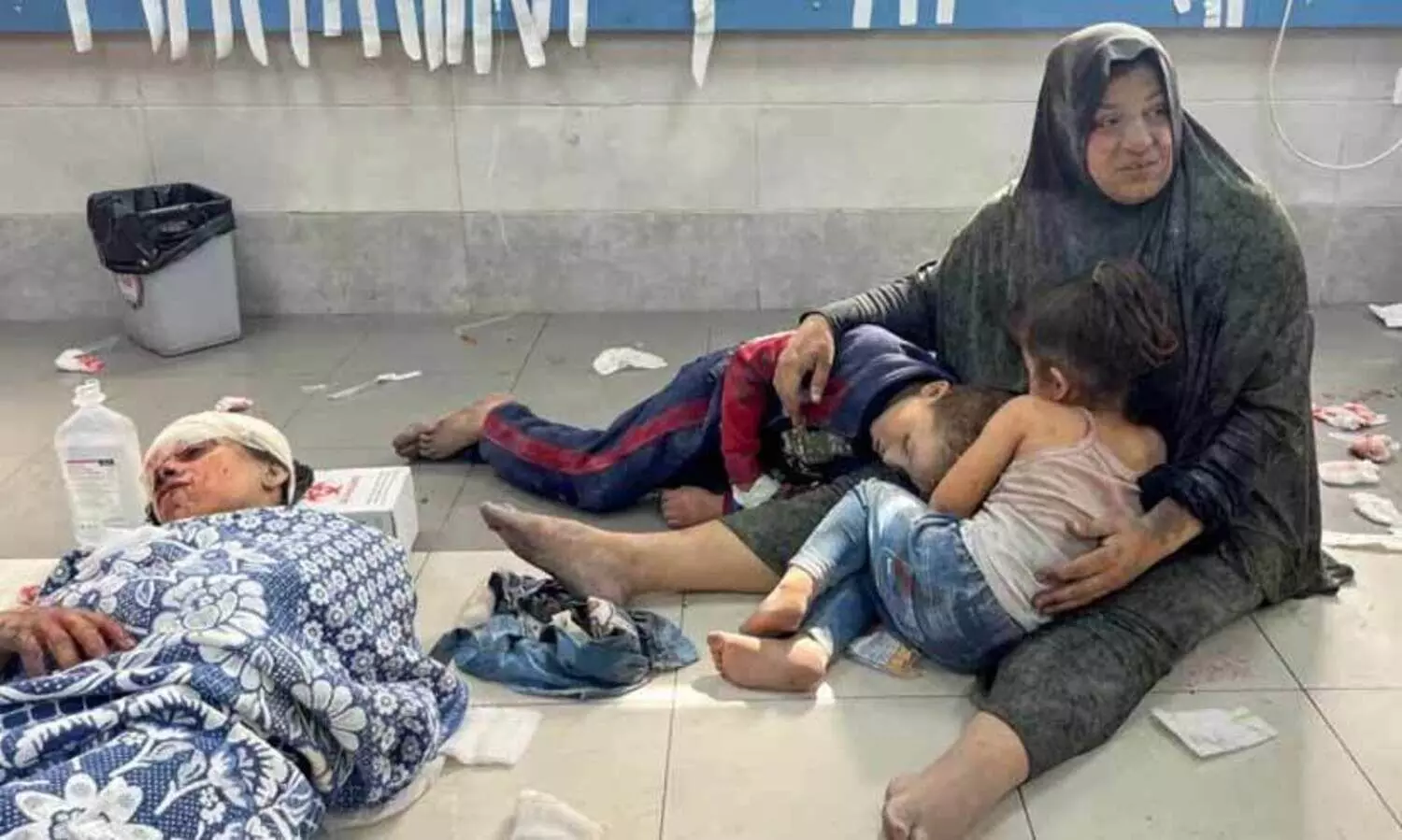 A Palestinian woman holds her children at Al-Shifa Hospital in Gaza City on October 23, 2023, after an Israeli air strike wounded the family