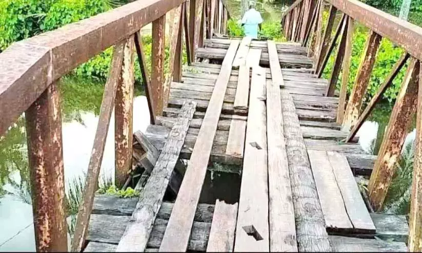 കി​ഴ​ക്കേ ക​രേ​ത്തോ​ടി​നു കു​റു​കെ​ അ​പ​ക​ട​ത്തി​ലാ​യ ന​ട​പ്പാ​ലം