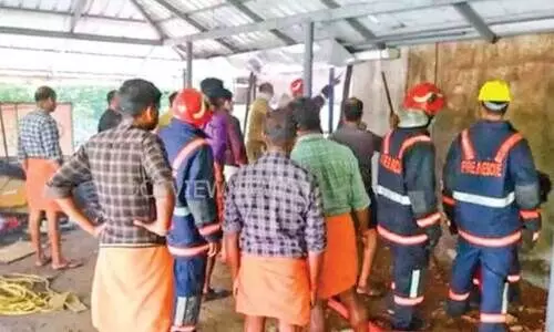 ഷൊ​ർ​ണൂ​ർ ടൗ​ണി​ലെ തീ​പി​ടി​ത്ത​മു​ണ്ടാ​യ ക​ട​യി​ലെ ചു​മ​ർ തു​ര​ക്കാ​ൻ ശ്ര​മിക്കുന്ന  അ​ഗ്നി​ര​ക്ഷ സേ​ന​ക്കാ​ർ