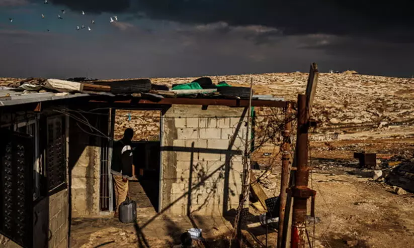 A Palestinian man inspects damage to his home he blames on Israeli settlers in the West Bank,