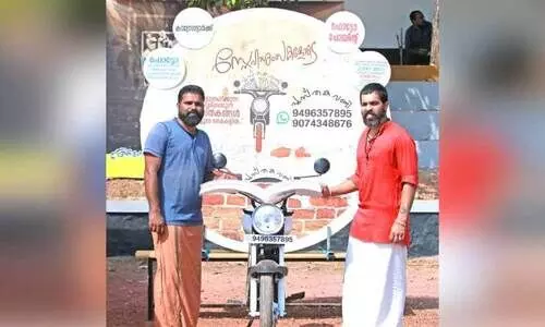 കാ​ട​ക​ത്തെ​ത്തി​യ ​ജ​യേ​ഷും ന​ബി​നും പു​സ്ത​ക​വ​ണ്ടി​യു​ടെ മു​ന്നി​ൽ