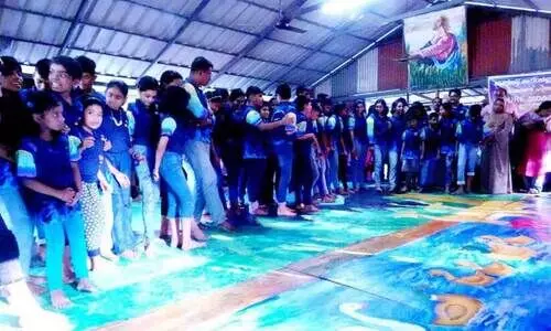 പ​രി​സ്ഥി​തി സം​ര​ക്ഷ​ണ സ​ന്ദേ​ശ​വു​മാ​യി അ​ധ്യാ​പ​ക​നും വി​ദ്യാ​ർ​ഥി​ക​ളും ചേ​ർ​ന്ന് കാ​ലു​കൊ​ണ്ട് ചി​ത്രം വ​ര​ക്കു​ന്നു