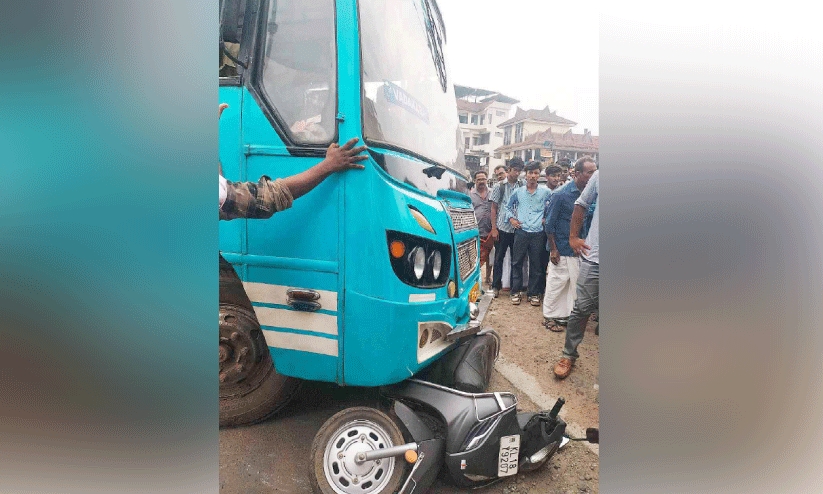 പ​യ്യോ​ളി ബ​സ് സ്റ്റാ​ൻ​ഡി​ന് മു​ന്നി​ൽ സ്വ​കാ​ര്യ ബ​സി​ന​ടി​യി​ൽ​പെ​ട്ട സ്കൂ​ട്ട​ർ