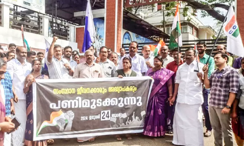പ​ണി​മു​ട​ക്കി​യ ജീ​വ​ന​ക്കാ​ർ ക​ല​ക്​​ട​റേ​റ്റി​ന് മു​ന്നി​ൽ  പ്ര​തി​ഷേ​ധി​ക്കു​ന്നു