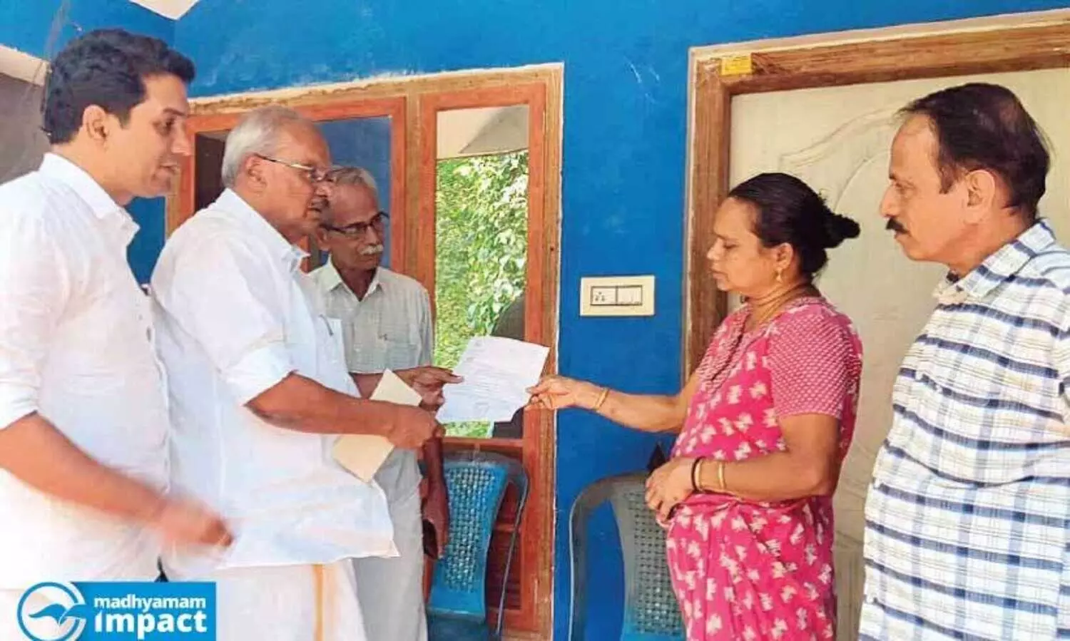 കേ​ര​ള ബാ​ങ്ക് ചെ​യ​ർ​മാ​ൻ ഗോ​പി കോ​ട്ട​മു​റി​ക്ക​ൽ പ​ഴ​യ​ന്നൂ​രി​ൽ സു​ധ​യു​ടെ വീ​ട്ടി​ലെ​ത്തി വാ​യ്പ ഇ​ള​വ​നു​ദി​ച്ച രേ​ഖ കൈ​മാ​റു​ന്നു