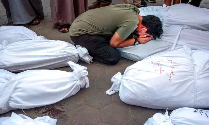 ഫലസ്തീനിൽ ബന്ധുക്കളുടെ മൃതദേഹങ്ങൾക്കു മുന്നിൽ കരയുന്ന ബന്ധു ഫലസ്തീനിൽ ബന്ധുക്കളുടെ മൃതദേഹങ്ങൾക്കു മുന്നിൽ കരയുന്ന ബന്ധു