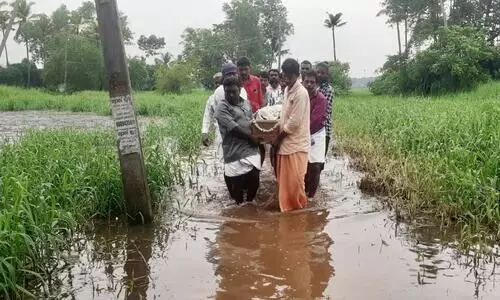 വയോധികന്റെ മൃതദേഹവുമായി വെള്ളക്കെട്ട് നീന്തി ബന്ധുക്കളും നാട്ടുകാരും വയോധികന്റെ മൃതദേഹവുമായി വെള്ളക്കെട്ട് നീന്തി ബന്ധുക്കളും നാട്ടുകാരും