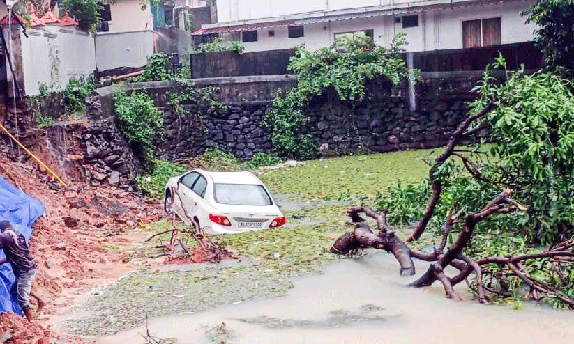 പടമുകൾ പാലച്ചുവട് റോഡിലെ ചിന്നമ്പിളിച്ചിറയിൽ സംരക്ഷണഭിത്തി ഇടിഞ്ഞ് പോർച്ചിൽ കിടന്നിരുന്ന കാർ ചിറയിൽ പതിച്ചപ്പോൾ പടമുകൾ പാലച്ചുവട് റോഡിലെ ചിന്നമ്പിളിച്ചിറയിൽ സംരക്ഷണഭിത്തി ഇടിഞ്ഞ് പോർച്ചിൽ കിടന്നിരുന്ന കാർ ചിറയിൽ പതിച്ചപ്പോൾ