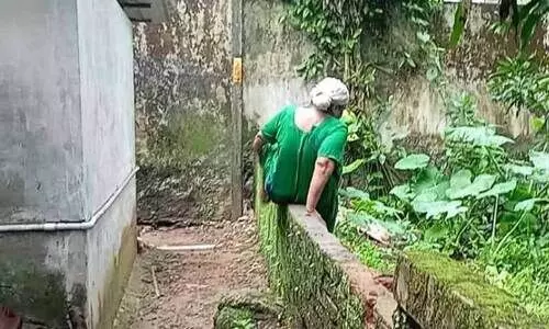 വ​ഴിയിൽ മാ​ലി​ന്യം നി​റ​ഞ്ഞ വെ​ള്ള​ക്കെ​ട്ട്; മ​തി​ൽ ചാ​ടിക്കടന്ന് കു​ടും​ബം