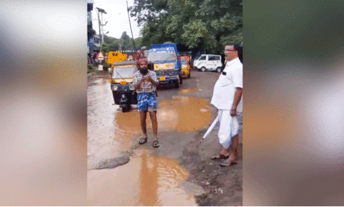 റോ​ഡി​ലെ വെ​ള്ള​ക്കെ​ട്ടി​ൽ ചൂ​ണ്ട​യി​ട്ട്​ ക​ലാ​കാ​ര​​ന്റെ പ്ര​തി​ഷേ​ധം