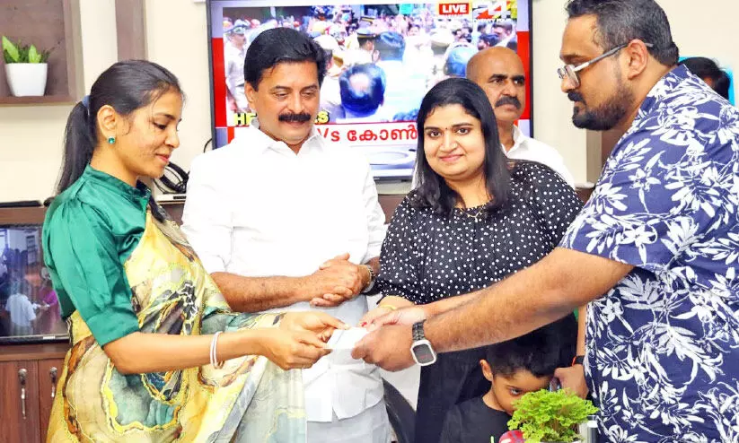 ധ​ന​സ​ഹാ​യം കൈ​മാ​റു​ന്നു