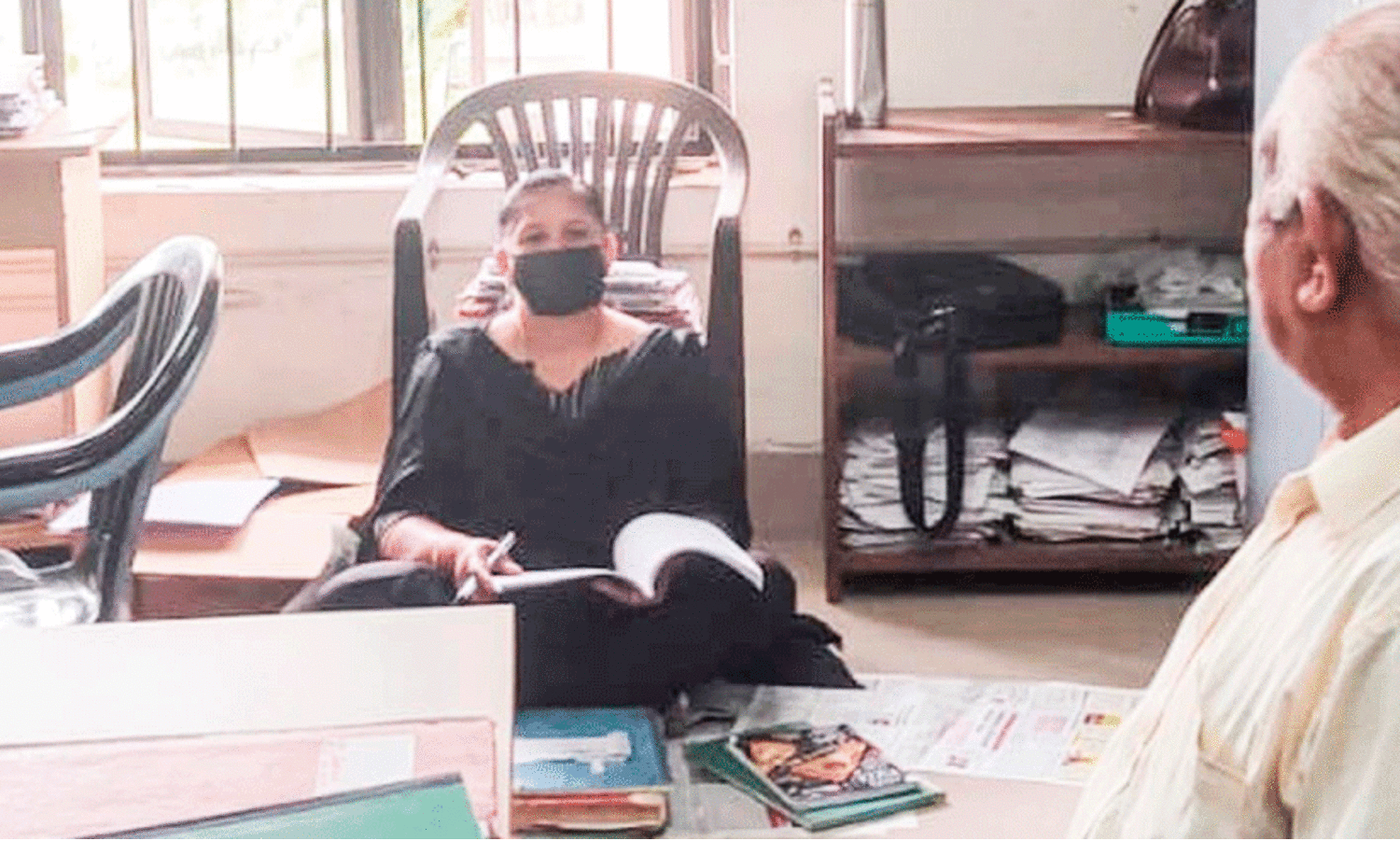 നിലത്തിരുന്ന് ജോലിചെയ്ത് പ്രതിഷേധിച്ച് വി.ഇ.ഒ നിലത്തിരുന്ന് ജോലിചെയ്ത് പ്രതിഷേധിച്ച് വി.ഇ.ഒ