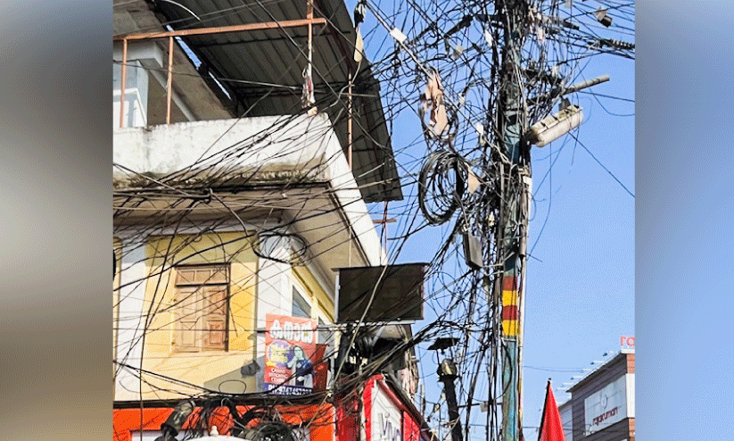 കേബിളുകളും കമ്പികളും കുരുങ്ങി വൈദ്യുതി പോസ്റ്റുകൾ
