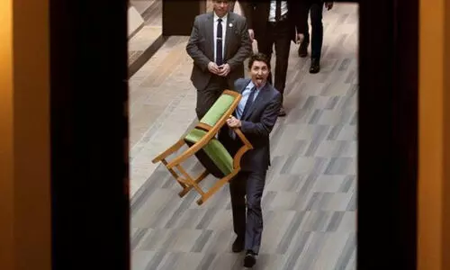 കസേര കൈയിൽ പിടിച്ച്, നാക്ക് പുറത്ത് കാട്ടി നാടകീയമായി ജസ്റ്റിൻ ട്രൂഡോ കനേഡിയൻ പാർലമെൻറിന്  പുറത്തേക്ക്